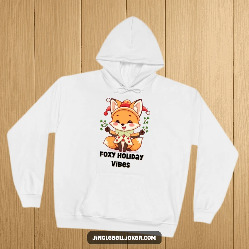 Funny Fox Jester Hoodie, a joyful fox in jester attire juggling mistletoe sprigs, perfect for cozy and humorous holiday wear.