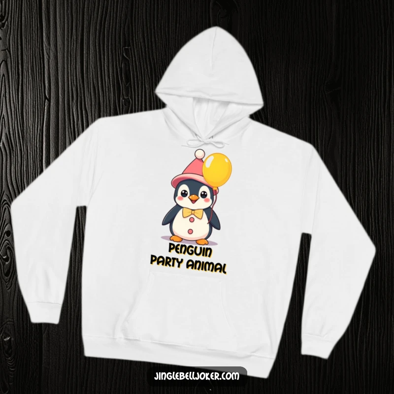 Funny kawaii penguin dressed as a clown holding a colorful balloon, a cozy hoodie perfect for spreading cheerful humor.