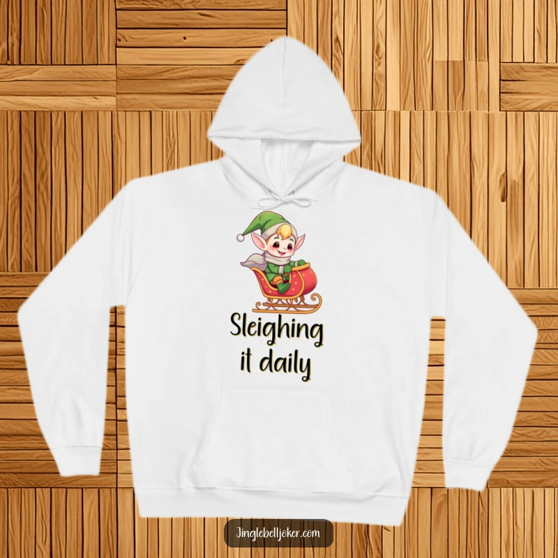 Funny hoodie graphic of a giddy elf joker riding a tiny, jingling sleigh, radiating festive energy and holiday delight.